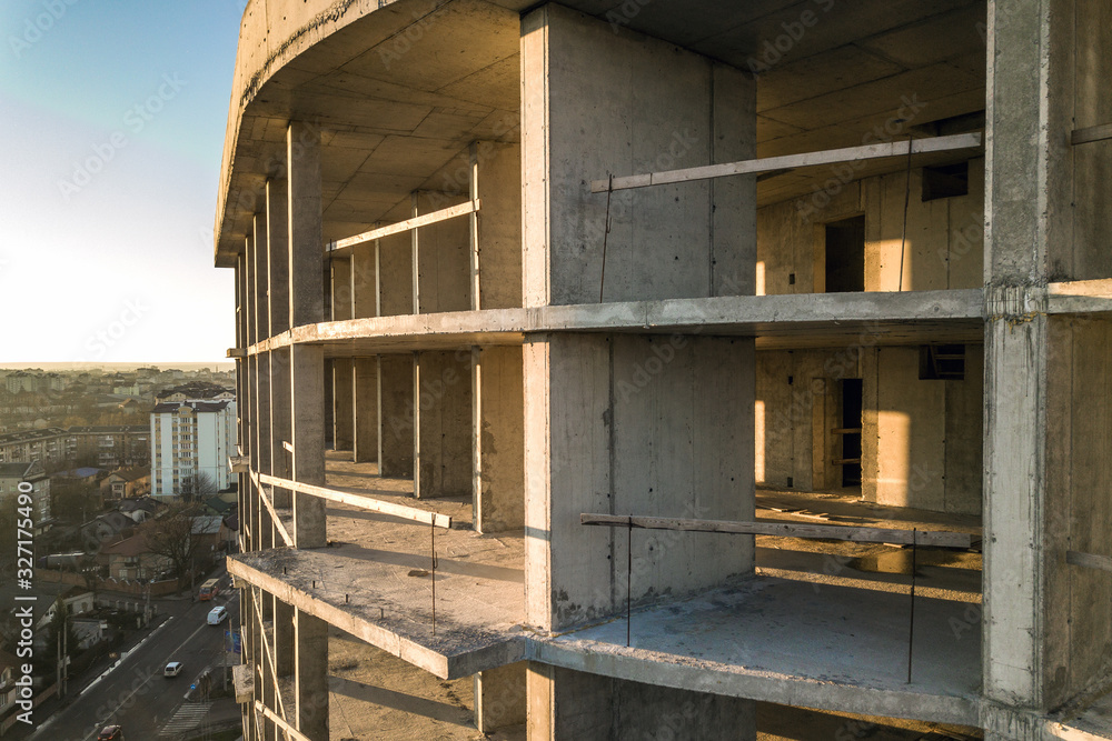 Obraz premium Aerial view of concrete frame of tall apartment building under construction in a city.