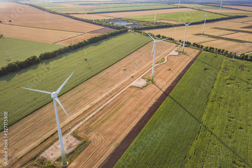 Aerial view of wind turbine generators in field producing clean ecological electricity. © bilanol