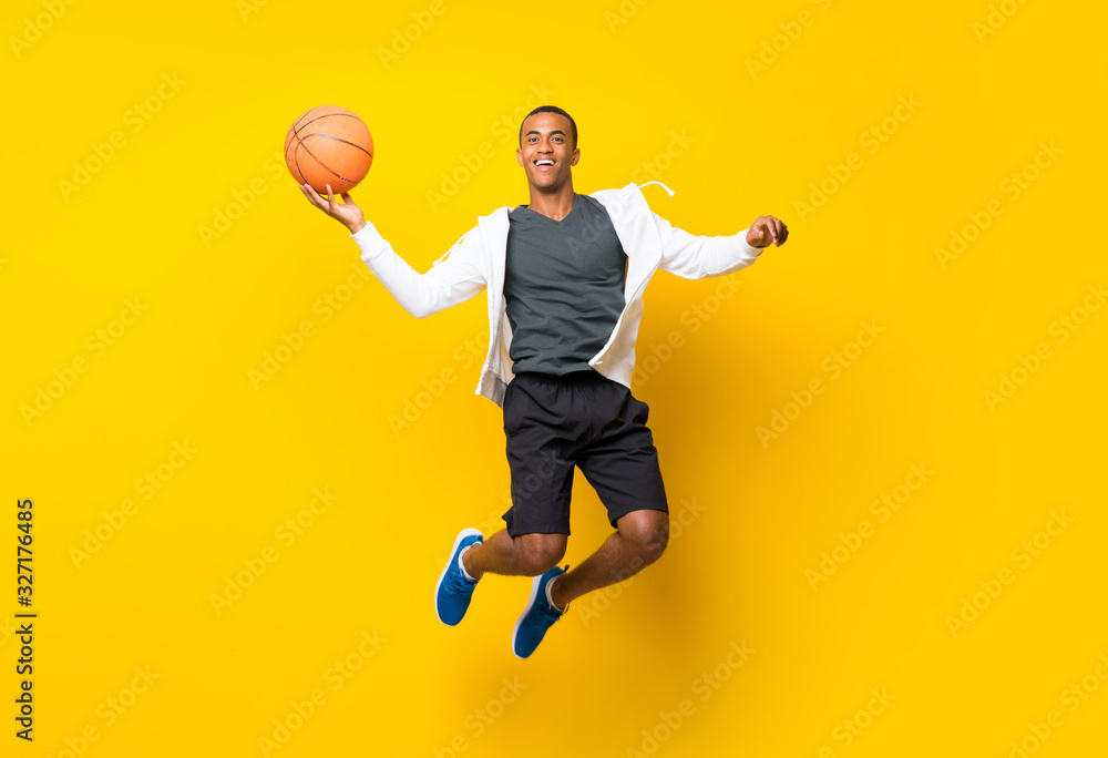 Fototapeta premium Afro American basketball player man over isolated yellow background
