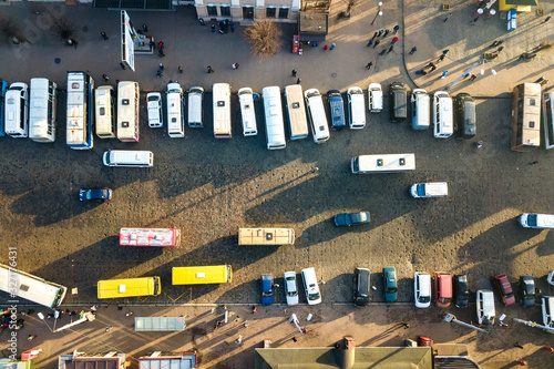 Aerial view of many cars and buses moving on a busy city street.