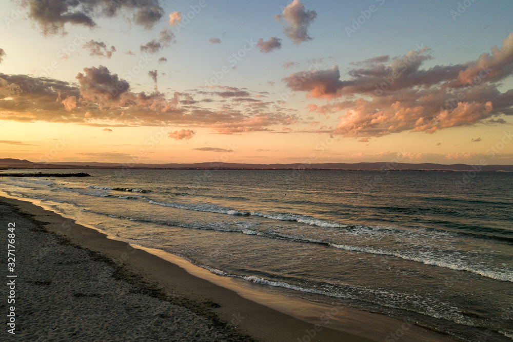Sea surface with blue water waves under yellow and purple sunset sky. Sea surface with blue water waves under yellow and purple sunset sky.