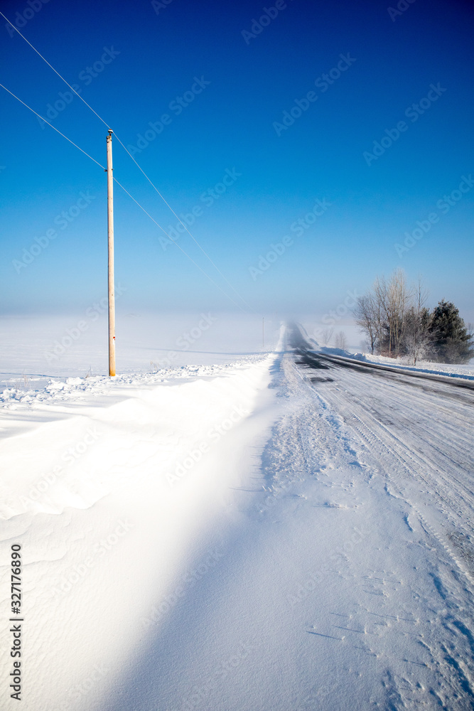 asphalt road covered with snow from the wind, vertical