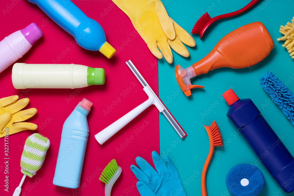 House cleaning product on red and green table background, housework and housekeeping concept House cleaning product on red and green table background, housework and housekeeping concept