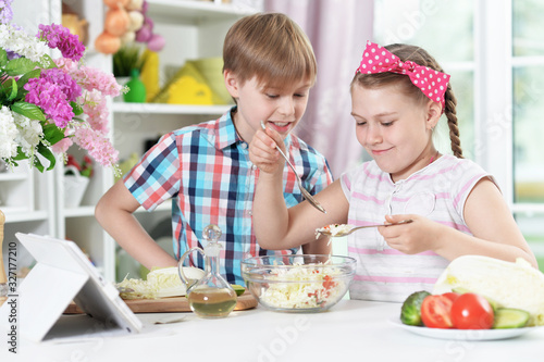 Cute brother and sister cooking together in kitchen