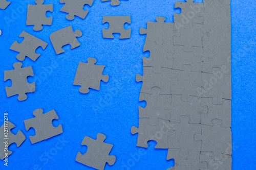  Gray puzzles on a blue background close-up