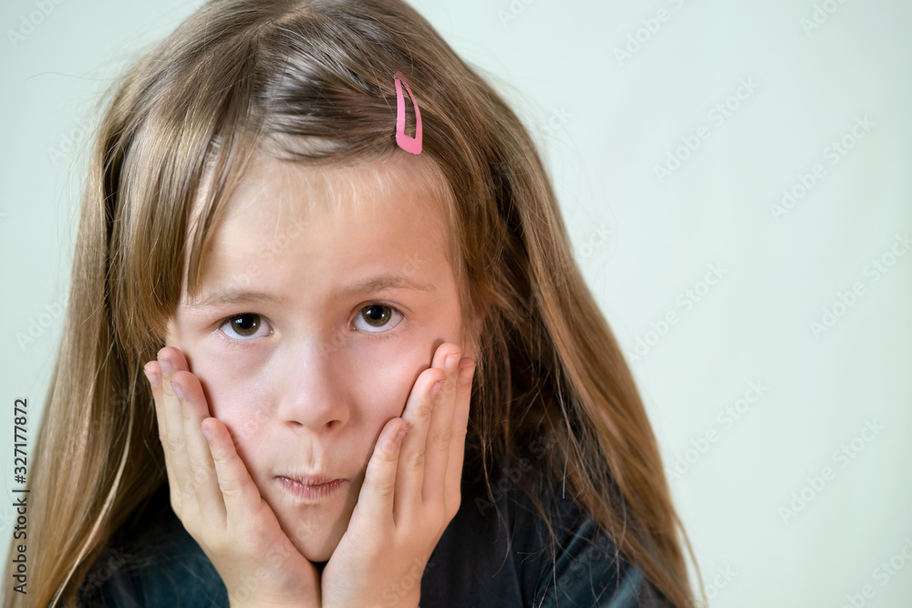 Close-up portrait of little child girl with long hair covering her mouth with hands. Close-up portrait of little child girl with long hair covering her mouth with hands.