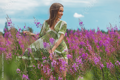 beautiful young woman in a green dress and pink lavender fields, Chamaenérion angustifolium