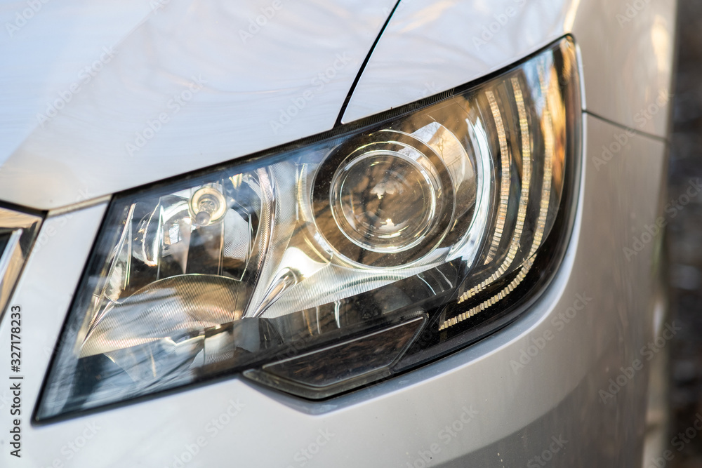 Close up view of modern car headlight with shiny optics.
