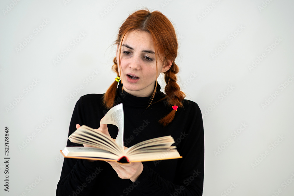 Young pretty girl read an open book in her hands. Reading and education concept. Young pretty girl read an open book in her hands. Reading and education concept.