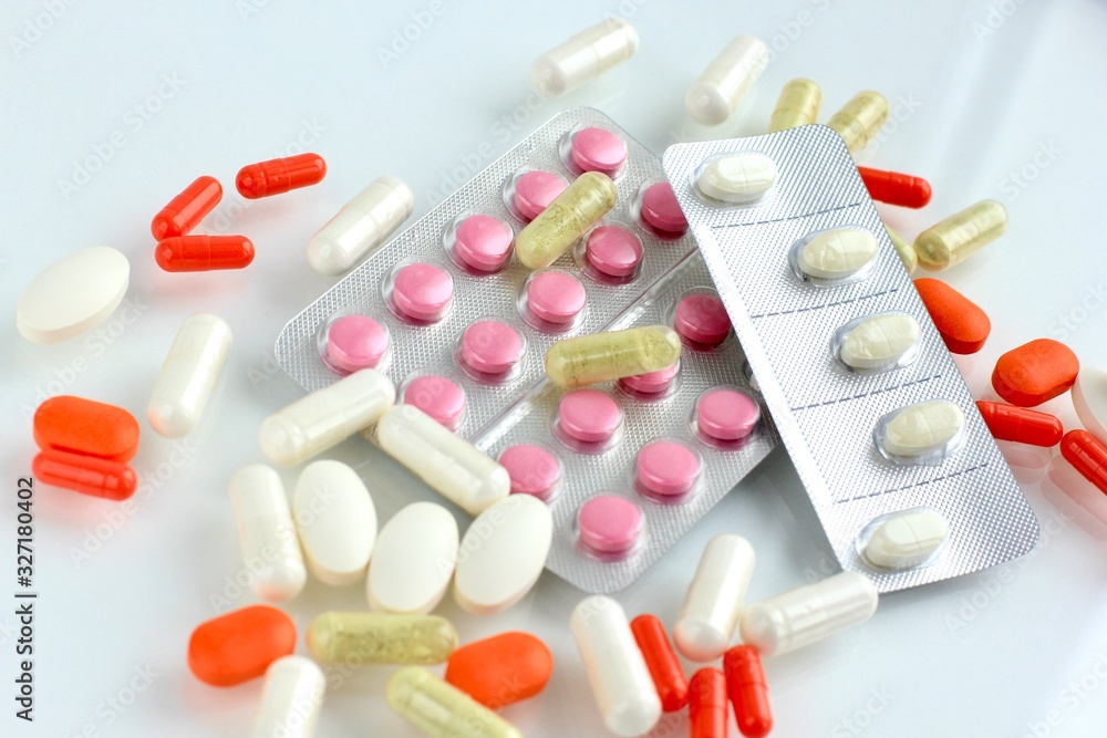 Multicolored pills, tablets against the virus, flu, disease on light background. Medical concept of Virus Pandemic Protection, Coronavirus COVID-19. Multicolored pills, tablets against the virus, flu, disease on light background. Medical concept of Virus Pandemic Protection, Coronavirus COVID-19.