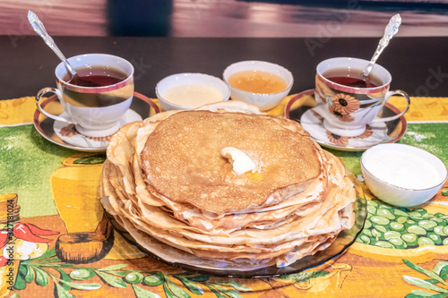 On the table, tea with pancakes, sour cream and jam for the Maslenitsa holiday, which is celebrated in Russia at the end of winter. photo