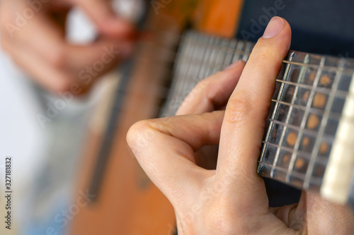 woman's hands playing acoustic guitar, close up photo