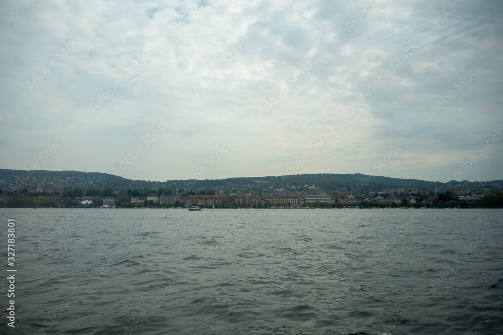 Charming panoramic scene of Zurich town looking from boat on limmat river with cloudy sky background , copy space , Switzerland