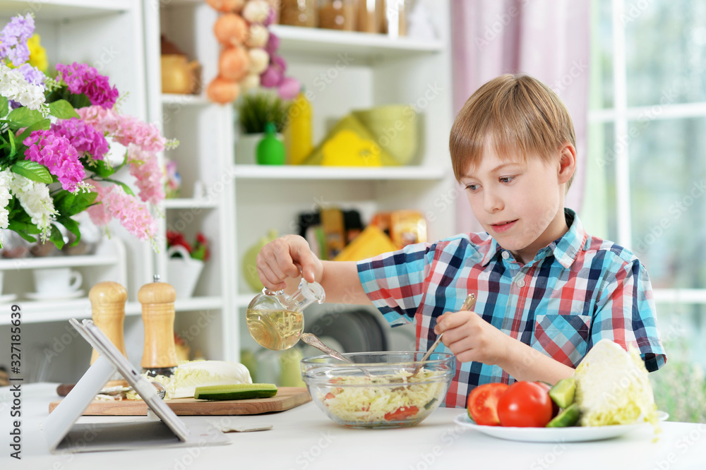Boy preparing delicious fresh salad in kitchen Boy preparing delicious fresh salad in kitchen