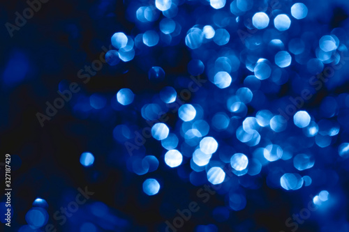 Abstract bright sparkling background, defocused christmas lights. Blurred background for holidays and parties in blue colors. Color of the year 2020.