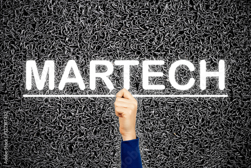 Woman showing MARTECH sign, on wire dark background. Martech is the blending of marketing and technology. photo