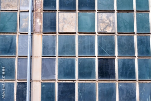 Facade of an old industrial office building with a predominance of old cement and old structural elements.