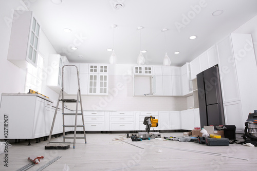 Canvas Print Renovated kitchen interior with stylish furniture, refrigerator and maintenance