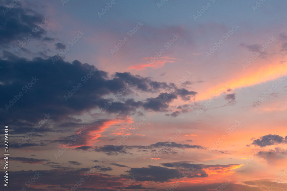 Orange sunset sky with gray and light clouds