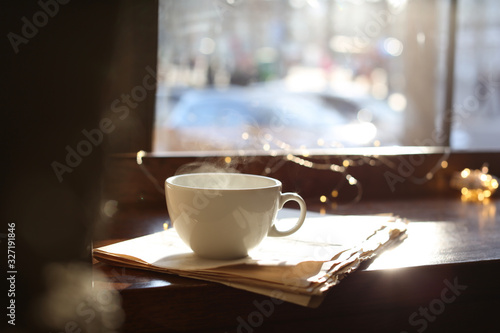 Delicious morning coffee and newspaper near window, indoors