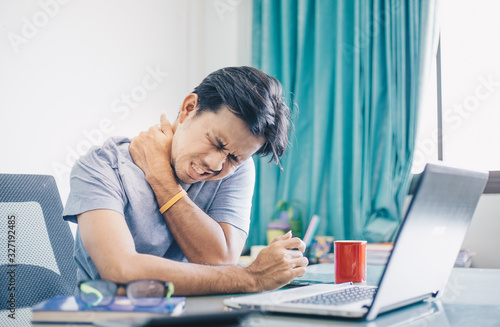 Young asian man suffering from neck pain in office ,Healthcare And Medicine concept, Office syndrome
