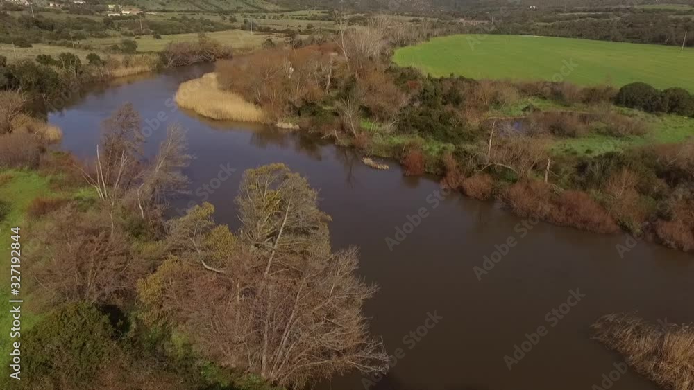 aerial view of the overflight of the lake and coghinas river in sardinia wrapped in trees and agricultural fields with the drone aerial view of the overflight of the lake and coghinas river in sardinia wrapped in trees and agricultural fields with the drone