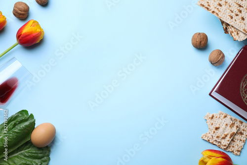 Flat lay composition with symbolic Pesach (Passover Seder) items on light blue background, space for text