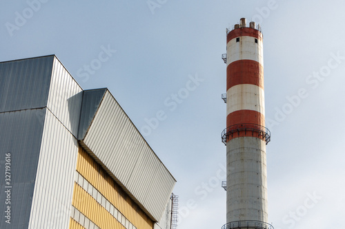 Tableau sur toile Building of the incinerator and the pipe against the sky, a sunny day