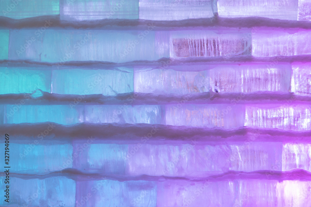Wall of ice blocks, multicolor lights. Background.