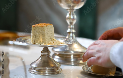 The liturgical liturgical bread of Prosphorus, Prosphora used during Orthodox worship. Preparation for Holy Communion. hands of the priest, icons placed on the altar of the Orthodox Church. The concep photo