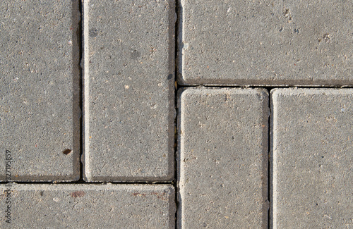 Background of rectangular gray tile sidewalk closeup. 6 tiles cast from concrete and cement abstractly located. Rough sandy texture.