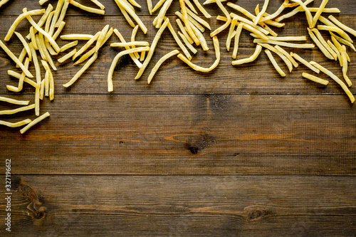 French fries frame on dark wooden background top-down copy space