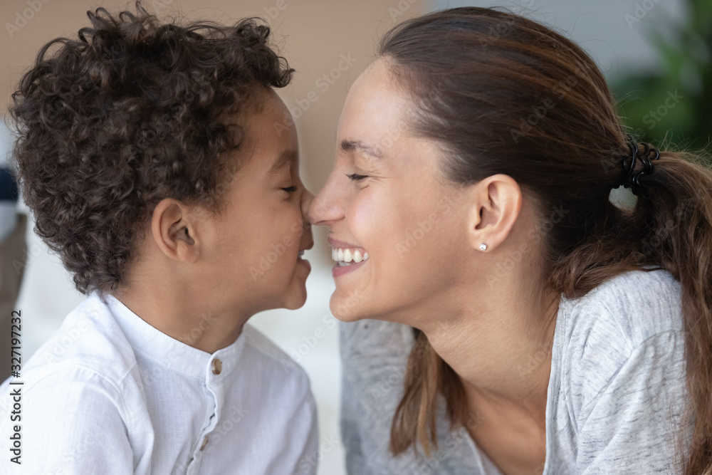 Naklejka premium Loving mother and African American son touching noses close up
