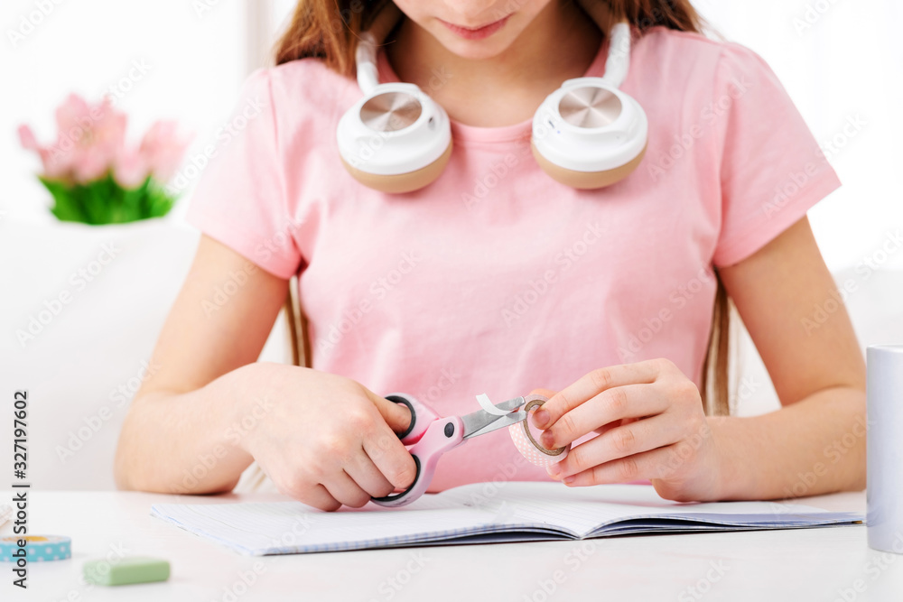 Young girl cutting a circle out of pink paper Young girl cutting a circle out of pink paper