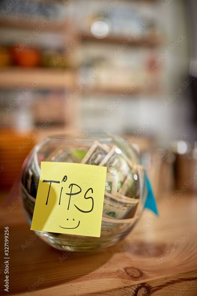 Money in the jar. Tips for a employee in coffee shop.