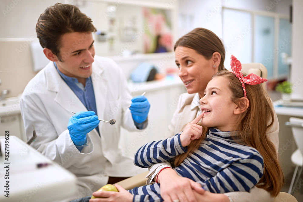 Litle patient showing tooth to dentist Litle patient showing tooth to dentist
