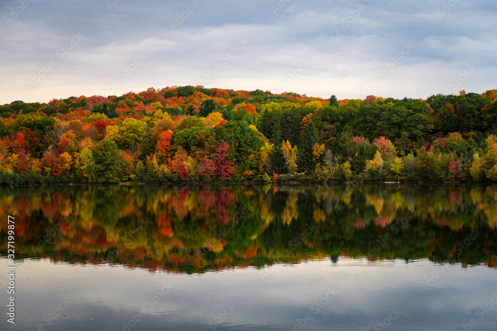 Colorful and autumnal trees reflecting in the water, at the St Bruno national park, Quebec