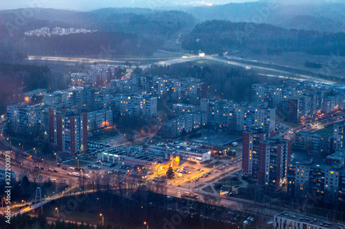 The view from the television tower to the city below. The areas of Vilnius. Buildings and streets. Vilnius TV tower. City at sunset. photo