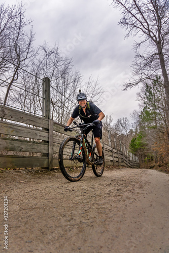 mountain biker on bridle path in umstead state park, raleigh NC. a wet cloudy day means the singletrack trails are closed so many cyclists take to the dual track of the park to enjoy the outdoors.
