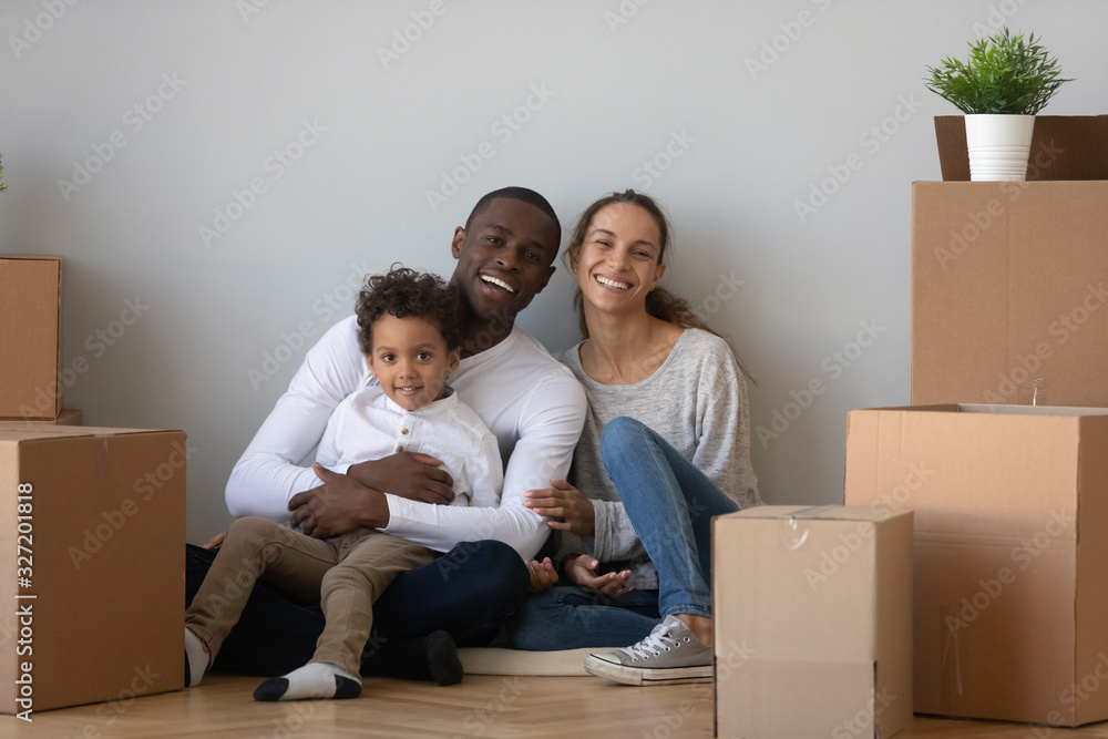 Portrait happy African American family with boxes in new apartment Portrait happy African American family with boxes in new apartment