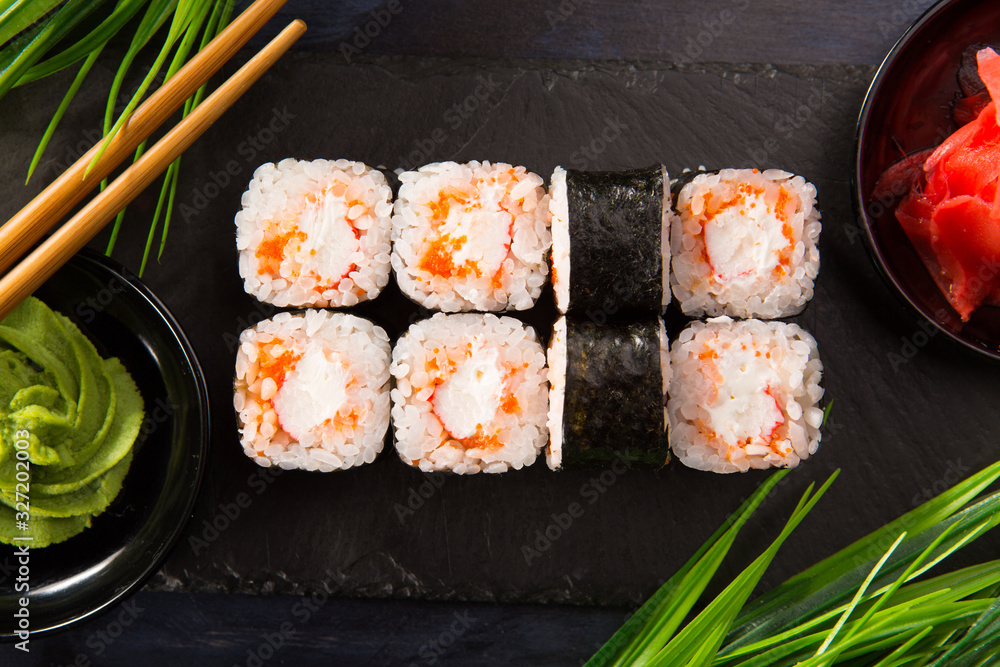Set of sushi rolls with wasabi and ginger on a black background. Japanese oriental cuisine Set of sushi rolls with wasabi and ginger on a black background. Japanese oriental cuisine
