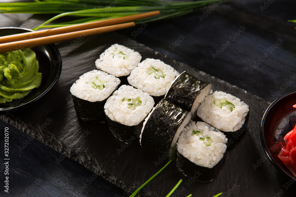 Set of sushi rolls with wasabi and ginger on a black background. Japanese oriental cuisine Set of sushi rolls with wasabi and ginger on a black background. Japanese oriental cuisine