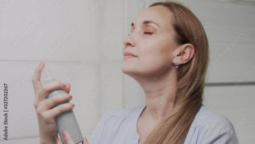 Close up Adult woman applying water spray for skin hydration Close up Adult woman applying water spray for skin hydration