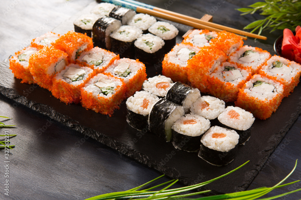 Set of sushi rolls with wasabi and ginger on a black background. Japanese oriental cuisine Set of sushi rolls with wasabi and ginger on a black background. Japanese oriental cuisine