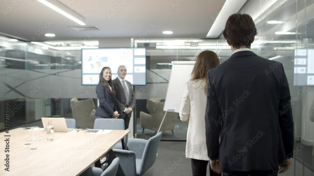 Smiling business people shaking hands in office. Cheerful business partners greeting each other. Business meeting concept Smiling business people shaking hands in office. Cheerful business partners greeting each other. Business meeting concept
