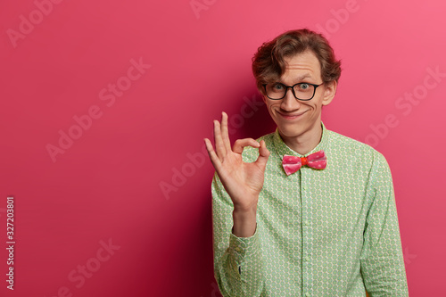 Bild auf Leinwand Positive European man shows okay gesture with fingers, says good job, excellent,