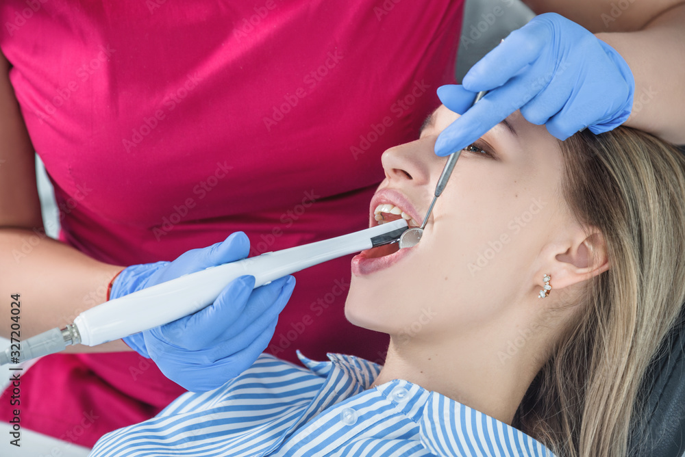 A dentist examines a patient, close-up of a patient with an open mouth next to which dental objects A dentist examines a patient, close-up of a patient with an open mouth next to which dental objects