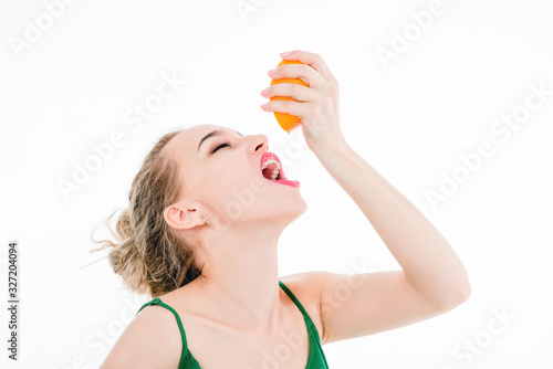 beautiful girl eating an orange on a white background, healthy eating concept