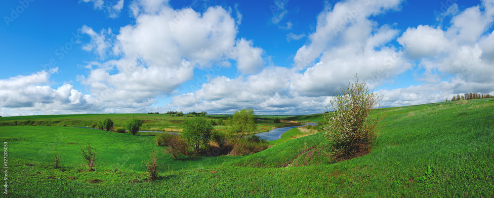 Spring landscape with river and green fields