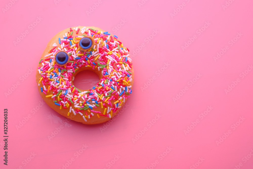 close up of donuts with funny face on color background .